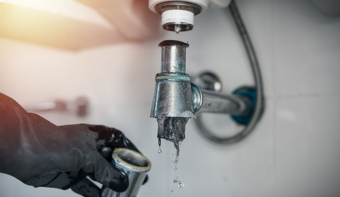 Clogged metal pipe under a sink