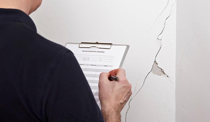 inspecting cracked wall